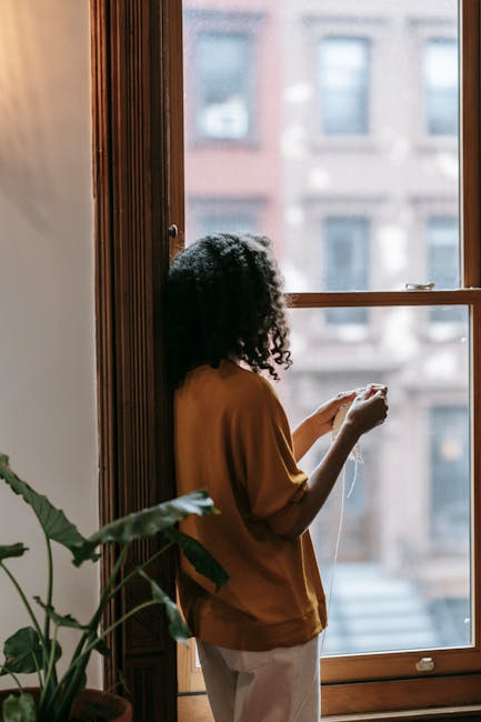 Woman meditating peacefully in a cozy, sunlit room with plants